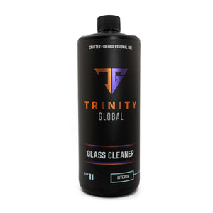 A black spray bottle labeled 'Trinity Global Glass Cleaner' with orange and white text indicating the product is for professional use and designed for glass.
