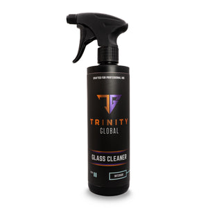 A black spray bottle labeled 'Trinity Global Glass Cleaner' with orange and white text indicating the product is for professional use and designed for glass.